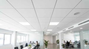 Forro modular com borda oculta e perfil invisível criando acabamento contínuo no teto