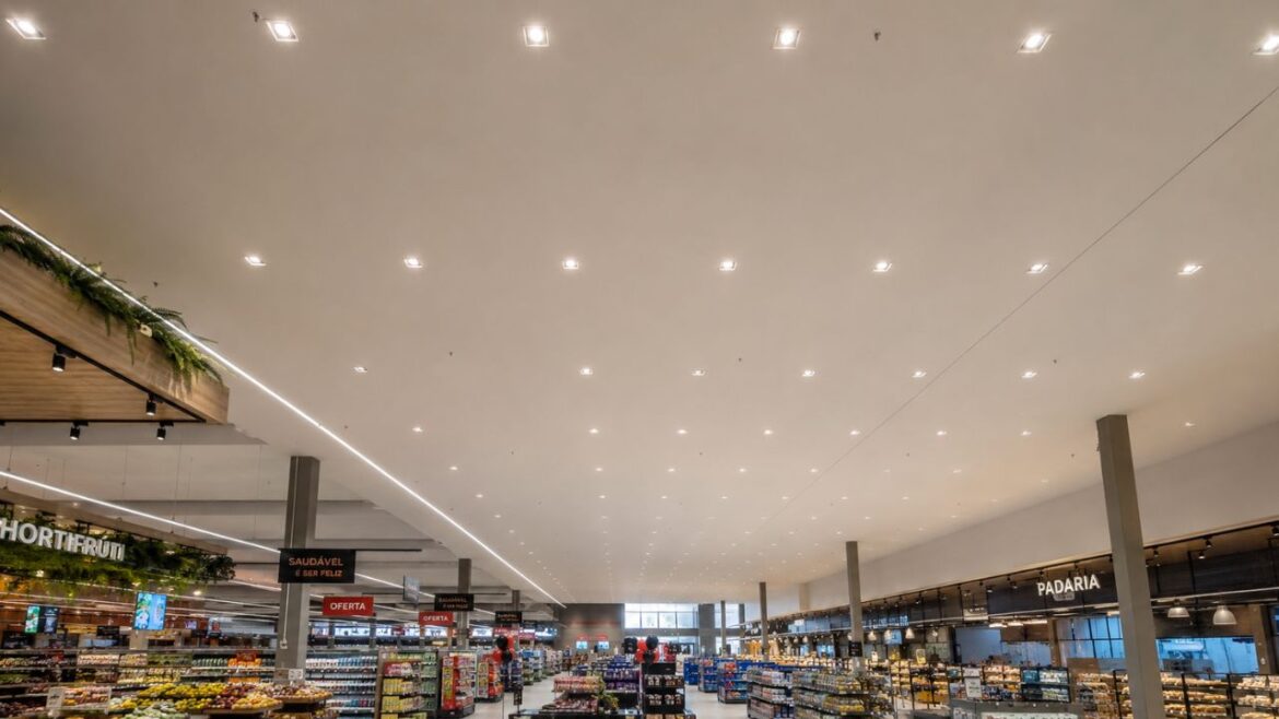 Interior de hipermercado com forro estruturado em drywall, iluminação embutida e amplo vão livre sem deformações aparentes
