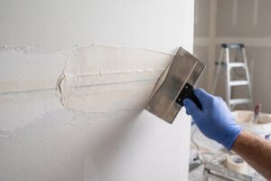 Aplicação excessiva de massa concentrada no centro da junta de drywall