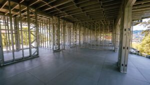 Vista interna de obra em Light Steel Frame com piso de laje seca (painéis estruturais) limpo e instalado sobre a estrutura metálica, mostrando a ausência de sujeira e a rapidez do sistema construtivo a seco.