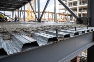 Detalhe construtivo de laje Steel Deck com chapa metálica trapezoidal galvanizada e concreto estrutural.